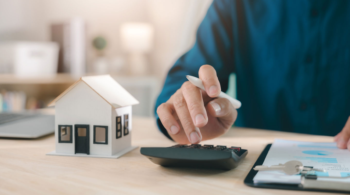 Gros plan sur un document de simulation de prêt immobilier avec un stylo soulignant la ligne TAEG parmi d'autres critères financiers